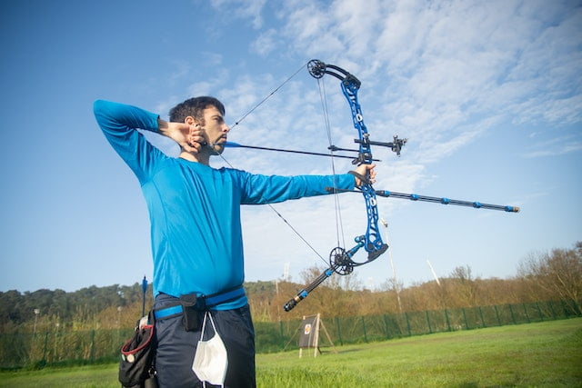 Man taking a shot with a bow and arrow.